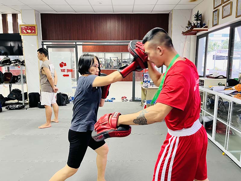 Hình ảnh người phụ nữ 50 tuổi đang vui khoẻ tập boxing